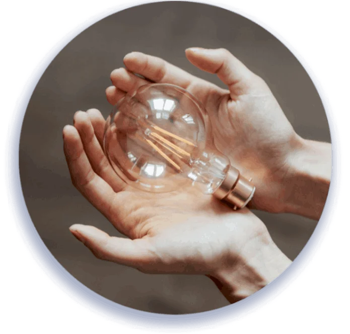 A person holding a glowing light bulb, symbolizing creativity and innovation.