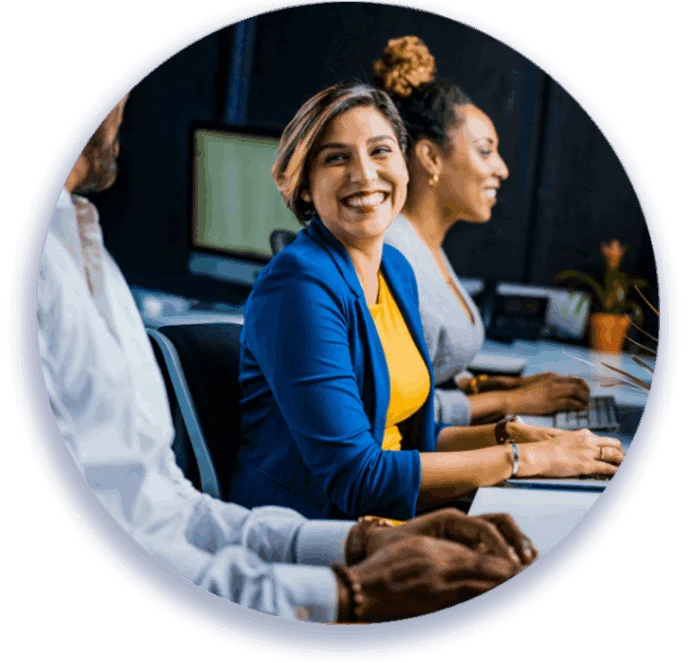 Three people at a desk, woman smiling.