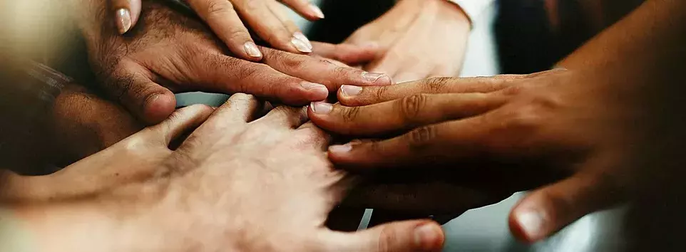 A diverse group of individuals holding hands in unity.